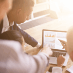 Group of people looking at graphs on a laptop
