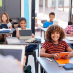Students use laptops in a classroom.